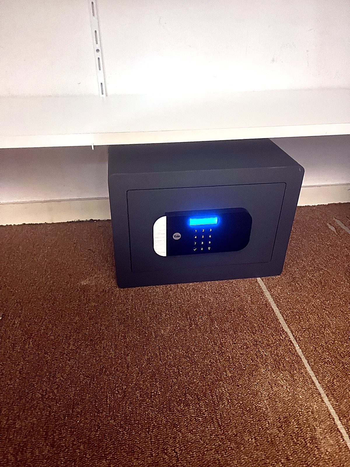 Coffre-fort Yale installé sous une étagère à Thoiry
